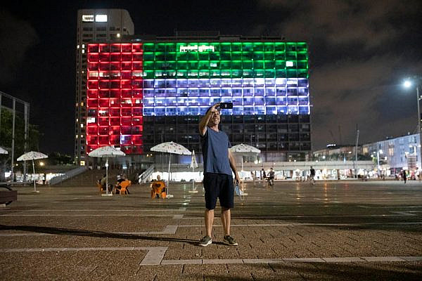 A man takes a selfie in front of the Tel Aviv Municipality on Rabin Square, which was lit up with the flag of United Arab Emirates after U.S. President Donald Trump announced the normalization of relations between Israel and the UAE, on August 13, 2020. (Oren Ziv)