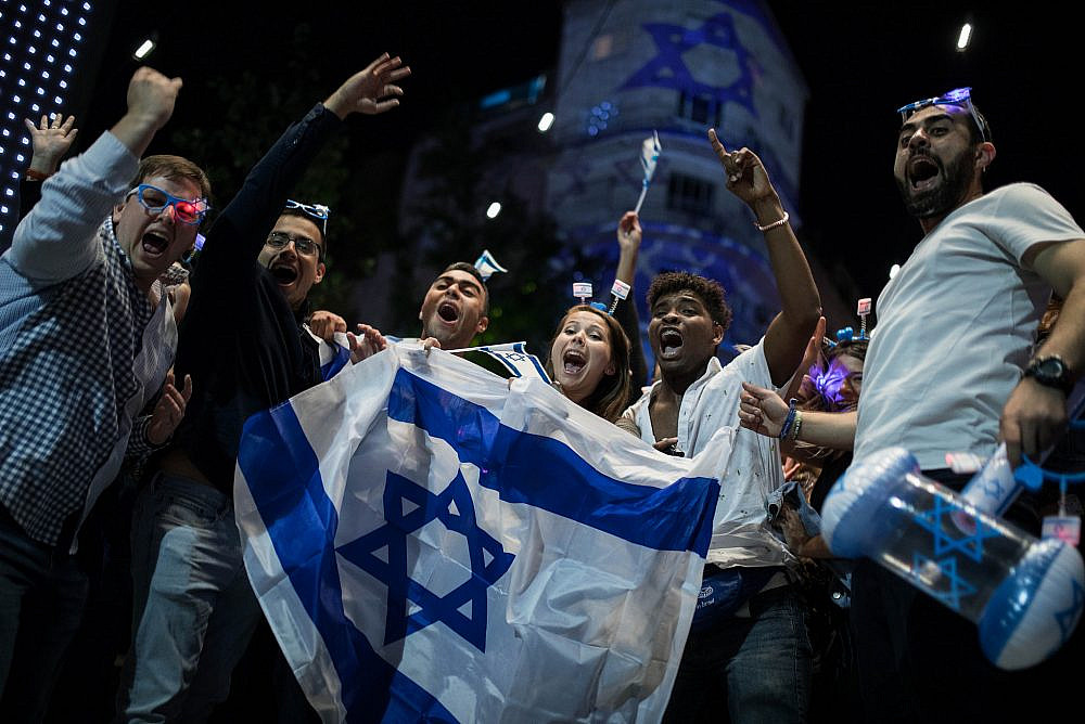 People wear Israeli flags as they take part in celebrations marking Israel's 71st Independence Day in Jerusalem, May 8, 2019. (Hadas Parush/Flash90)