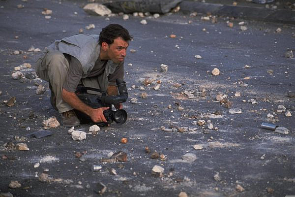 A TV journalist covering protests in the occupied West Bank during the Second Intifada, October 8, 2000. (Oded Baliti/GPO)