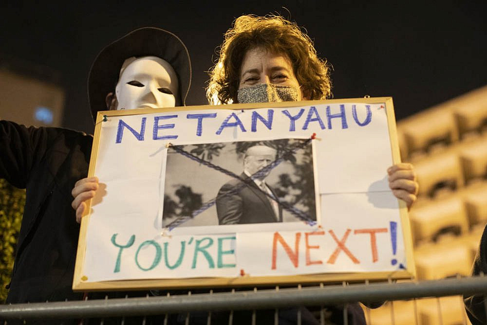 An anti-Netanyahu protester holds up a sign reading 'Netanyahu, you're next' during a demonstration against the prime minister following the election of Joe Biden to the presidency of the U.S., Jerusalem, November 7, 2020. (Oren Ziv)