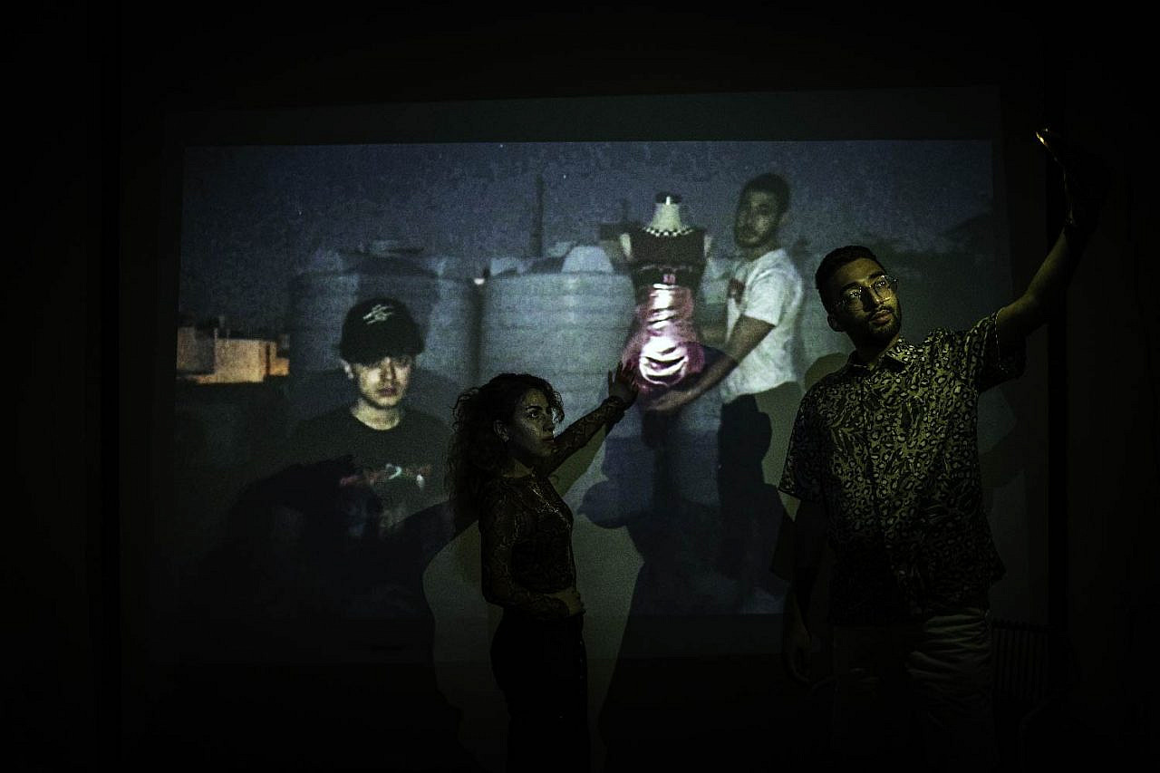 Members of tRASHY in Amman, Shukri Lawrence and Omar Braika, pose for a picture while being projected onto co-designers Reem Kawasmi and Luai Al-Shuaibi, in the city of Bethlehem on August 21, 2020. (Samar Hazboun)