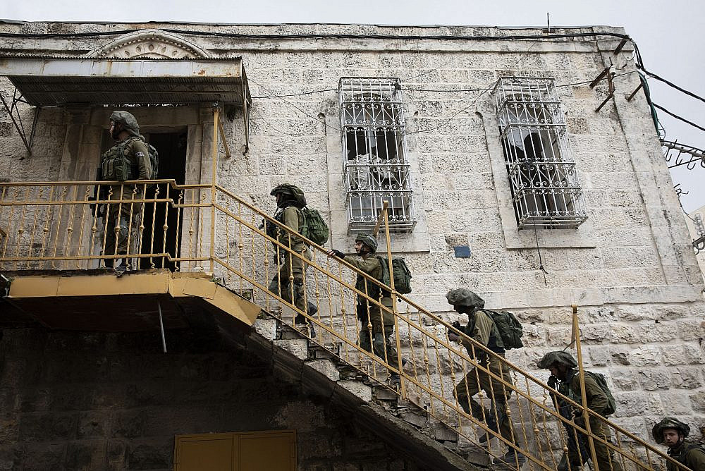 Israeli soldiers raid a Palestinian house as hundreds of demonstrators march in the West Bank city of Hebron calling to open Shuhada Street, February 20, 2019. (Activestills.org)
