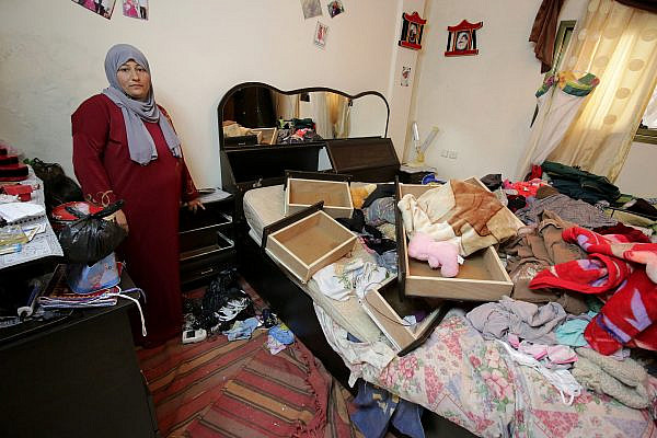 A Palestinian woman examines the damage in her house after a night raid by Israeli soldiers, Balata Refugee Camp, West Bank, January 3, 2017. (Ahmad Al-Bazz/Activestills.org)