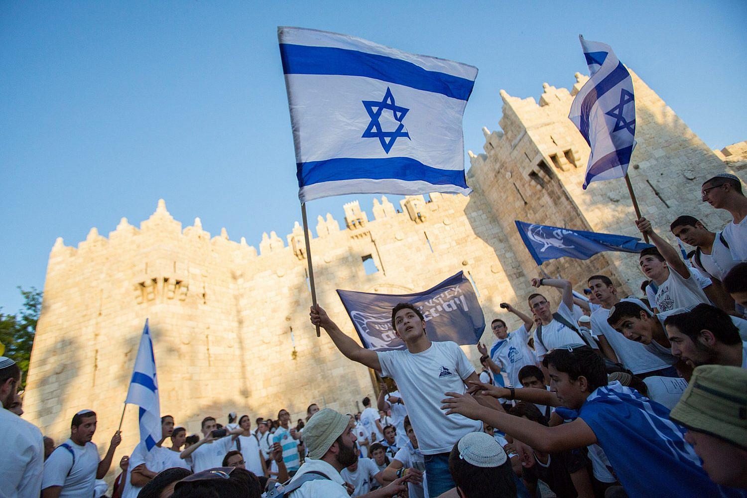 Thousands of young Jewish boys wave Israeli flags as they celebrate Jerusalem Day, dancing and marching their way through Damascus Gate to the Western Wall, May 17, 2015. (Yonatan Sindel/Flash90)