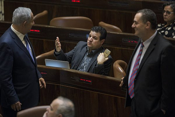 Prime Minister Benjamin Netanyahu and Joint List party chairman Ayman Odeh talk during a vote at the Knesset on November 18, 2015. (Hadas Parush/Flash90)