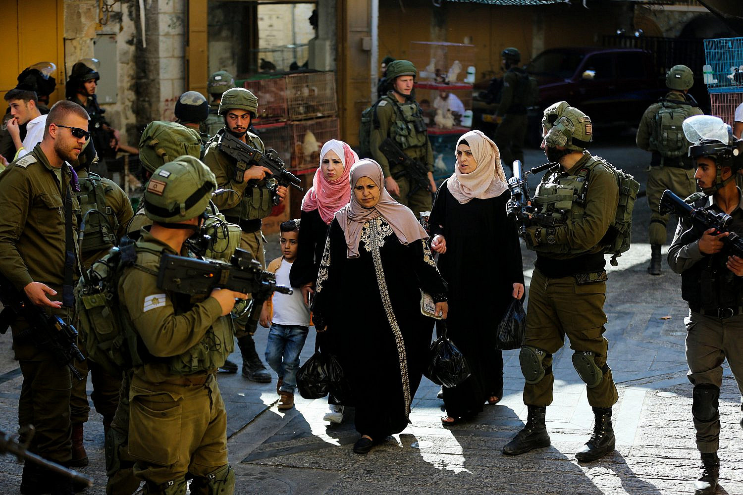 Israeli security forces guard as Jews tour the Palestinian side of the Old City Market in the West Bank city of Hebron, June 15, 2019. (Wisam Hashlamoun/Flash90)