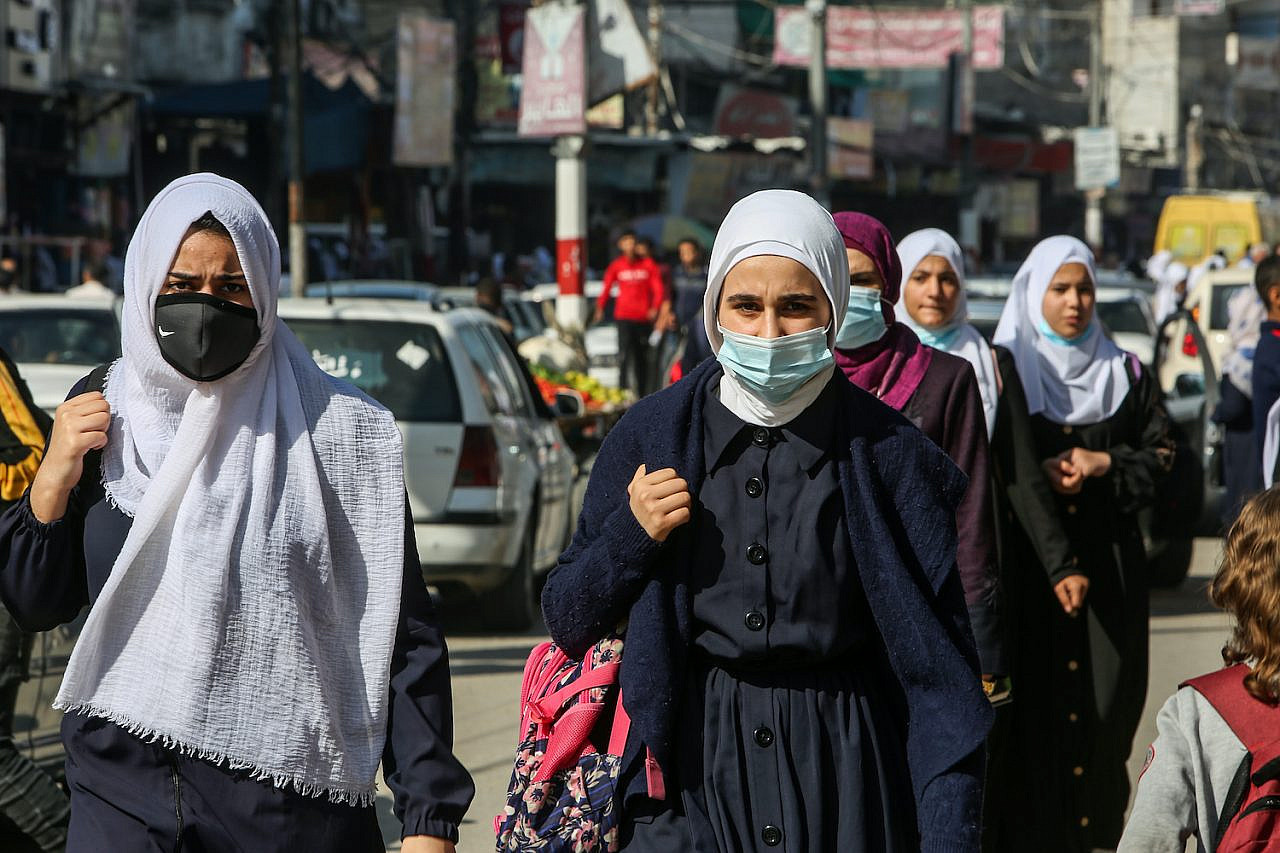 Palestinians wearing face masks walk in a main street in Rafah, Gaza on November 19, 2020. (Abed Rahim Khatib/Flash90)
