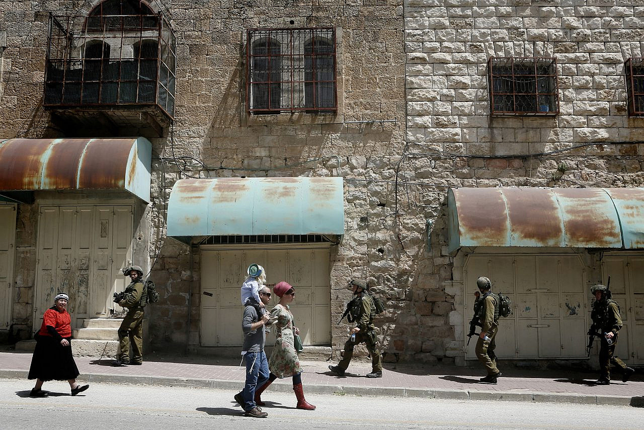 Israeli soldiers patrolling on Shuhada Street in the West bank city of Hebron, as hundreds of Orthodox Jews arrive to pray at the Cave of the Patriarch, during the Jewish holiday of Passover. April 16, 2014. (Miriam Alster/Flash90)