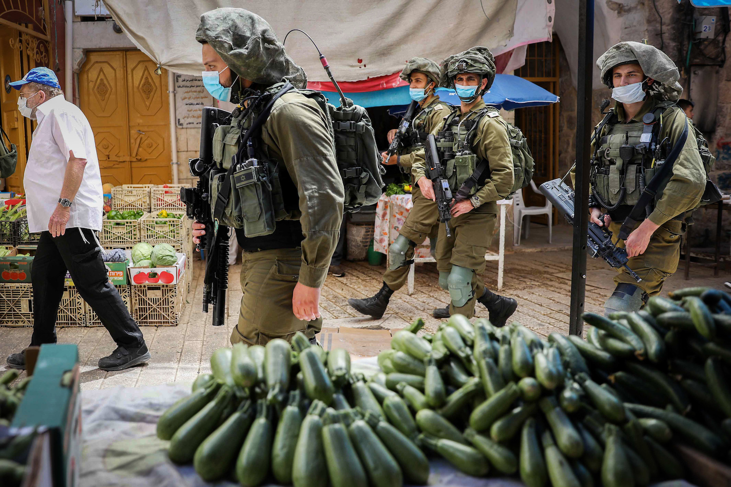 I soldati israeliani accompagnano un gruppo di turisti ebrei nella città di Hebron in Cisgiordania, il 16 maggio 2020 (Wisam Hashlamoun / Flash90)