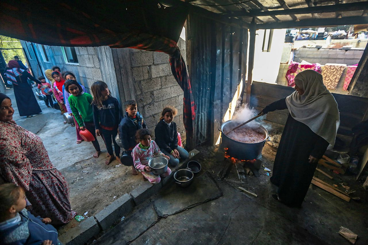 A woman serves food to Palestinian children in Gaza City, Gaza on January 21, 2021. (Mohammed Zaanoun)