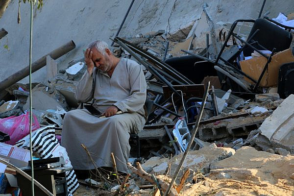 Palestinians check the damage caused after a 15-floor building was destroyed in an Israeli airstrike in Gaza City, on May 13, 2021. (Atia Mohammed/Flash90)