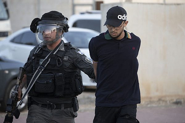 An Israeli police officer arrests a Palestinian during confrontations in the city of Lydd, central Israel. (Oren Ziv)