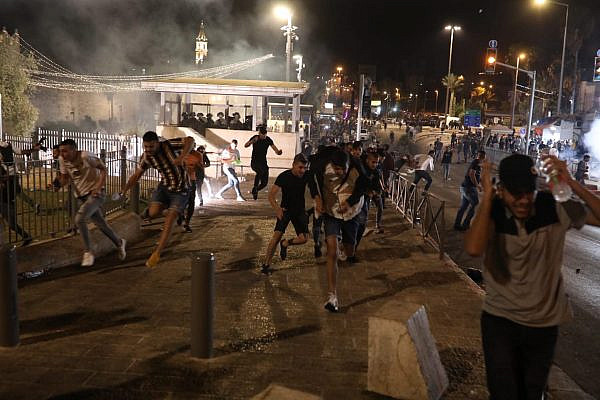 Palestinian demonstrators flee after Israeli security forces fire tear gas outside Damascus Gate, Jerusalem, May 8, 2021. (Oren Ziv)
