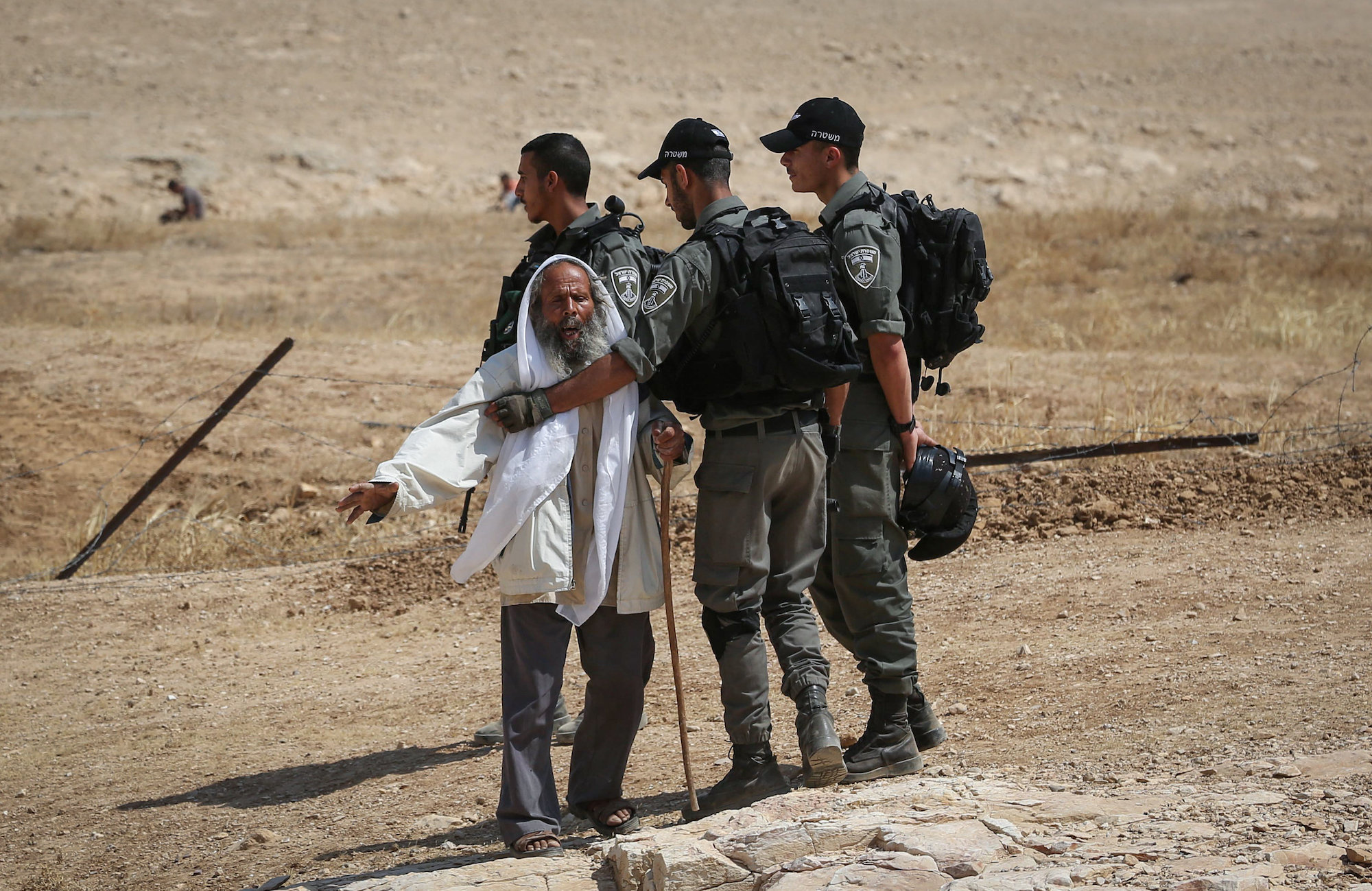 Israeli troops hold back a Palestinian man as they demolish sheds belonging to Palestinians in the South Hebron Hills, June 12, 2019. (Wisam Hashlamoun/Flash90)