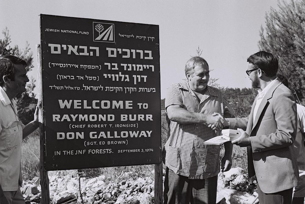 Raymond Burr and Don Galloway, the stars of American television series 'Ironside' which was hugely popular in Israel, plant a tree in Biria Forest, created by the JNF on the ruins of the villages Mughr al-Kheit, Ein A-Zeitun, Amuqa, Fir’im, and Qabaʿa, 1974. (Moshe Milner/GPO)
