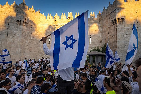 Israelis hold flags and dance during the Flag March at Damascus Gate in Jerusalem's Old City, June 15, 2021. (Olivier Fitoussi/Flash90)