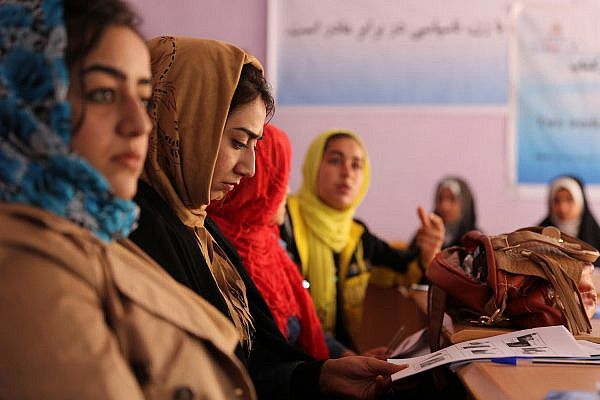 A journalist reviews her training guide during photojournalism training at the Directorate of Women's Affairs building in Farah City, Afghanistan, February 10, 2013. (Josh Ives/U.S. Navy)