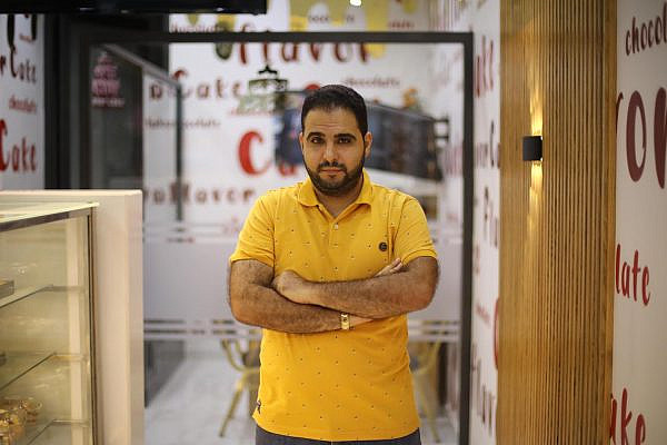 Baraa Rantisi posing at Flavor Cake, the bakery he owns in Gaza City which suffered losses due to the May war on Gaza, September 2, 2021. (Mohammed Zaanoun)