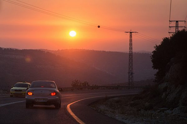 The sun sets over a road in the occupied West Bank. July 22, 2017. (Hadas Parush/Flash90)