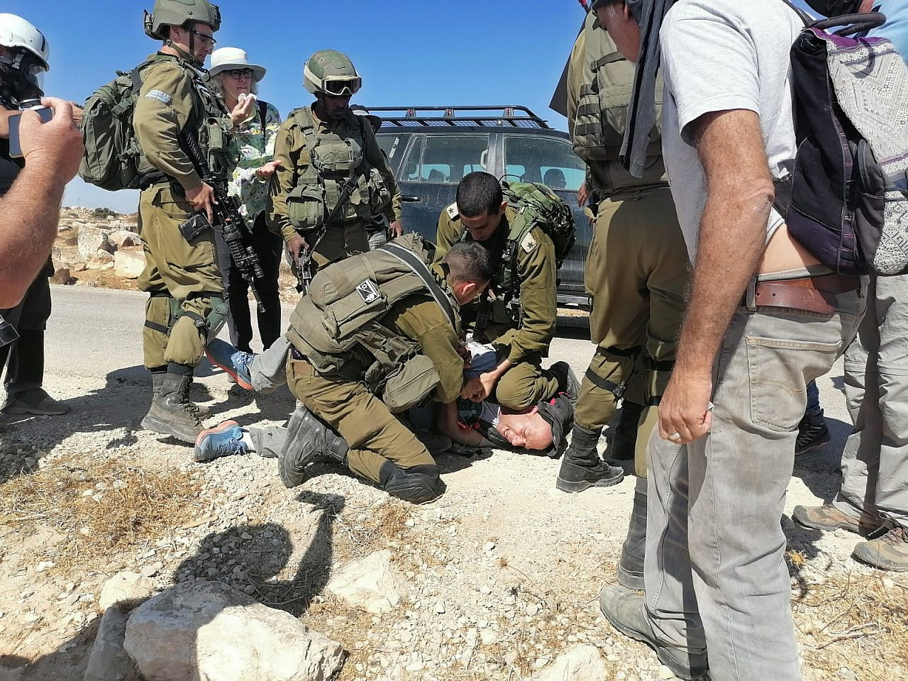 Israeli soldiers arrest an activist during a protest in the South Hebron Hills; one of the soldiers bears a Punisher/Star of David patch, Sept. 17, 2021. (Osama Elewat)