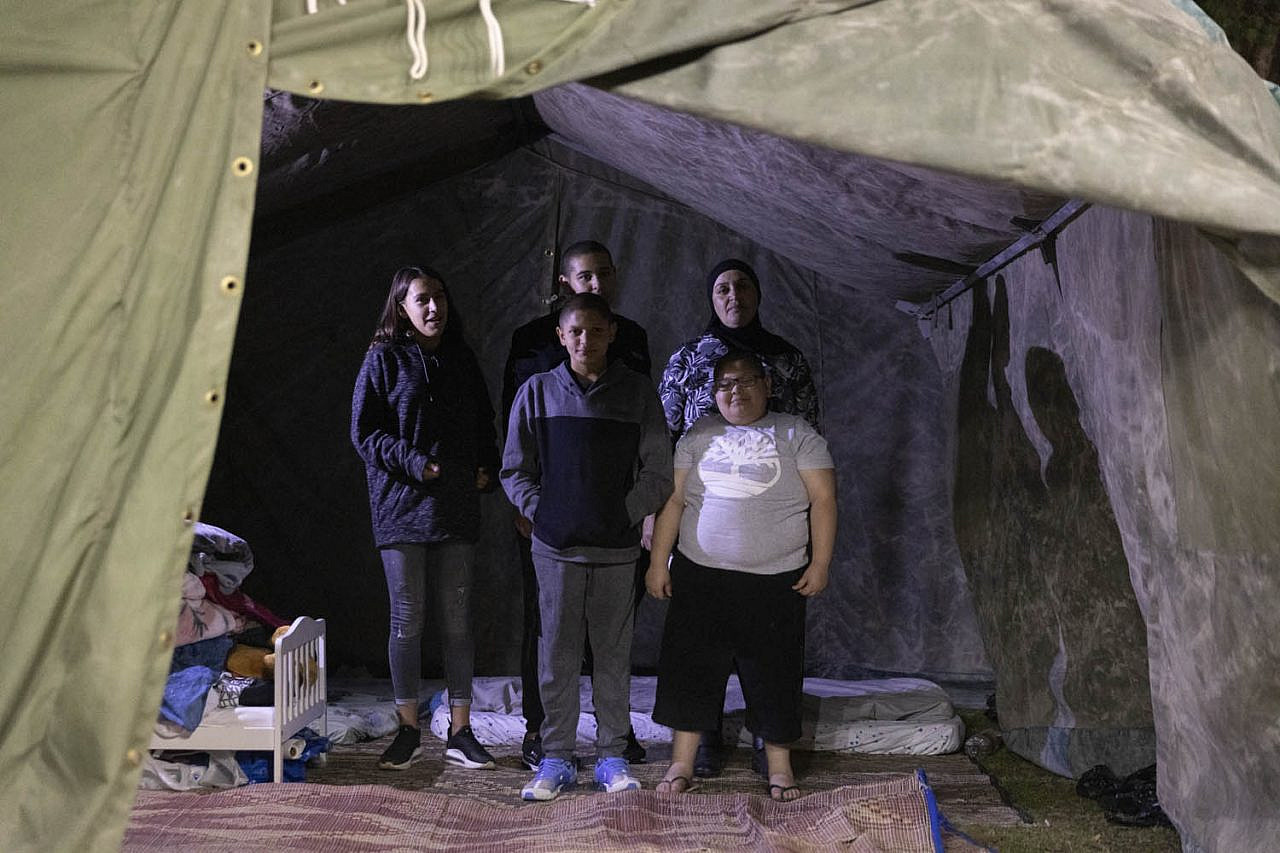 Farida Najar, a Palestinian single mother of four, seen with her children inside the tent she erected in a public park in Jaffa, in protest of racialized gentrification and rising rents in the city, November 17, 2021. (Oren Ziv)