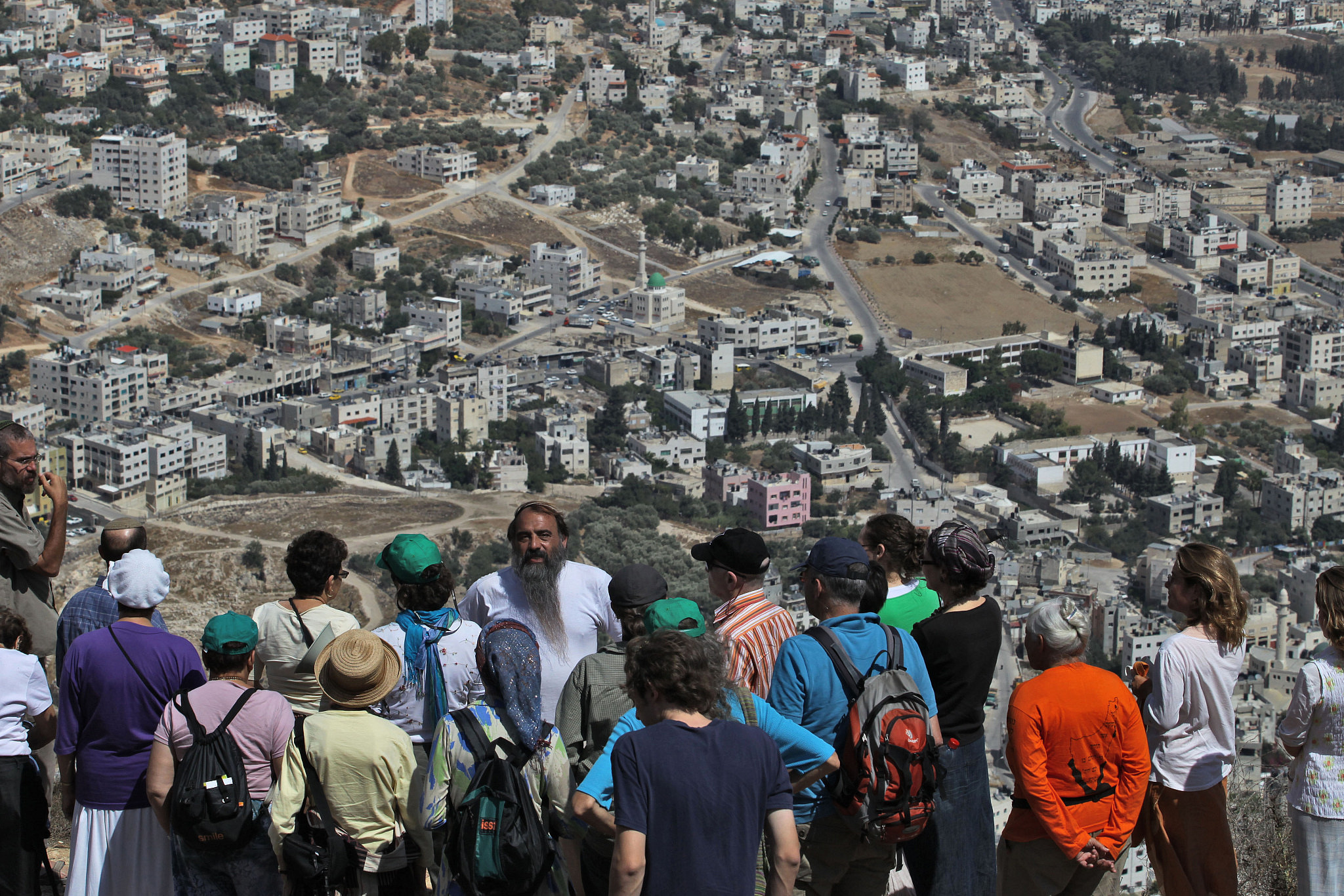 Religious Jews listen to a guide near Joseph's Tomb in the West Bank town of Nablus as they attend a tour led by activist Nadia Matar (not seen) of the Jewish settlements in the West Bank. Matar believes that the Land of Israel including the West Bank and Gaza was promised and belongs to the Jewish People, according to the Torah. September 23, 2009. (Nati Shohat/Flash90)