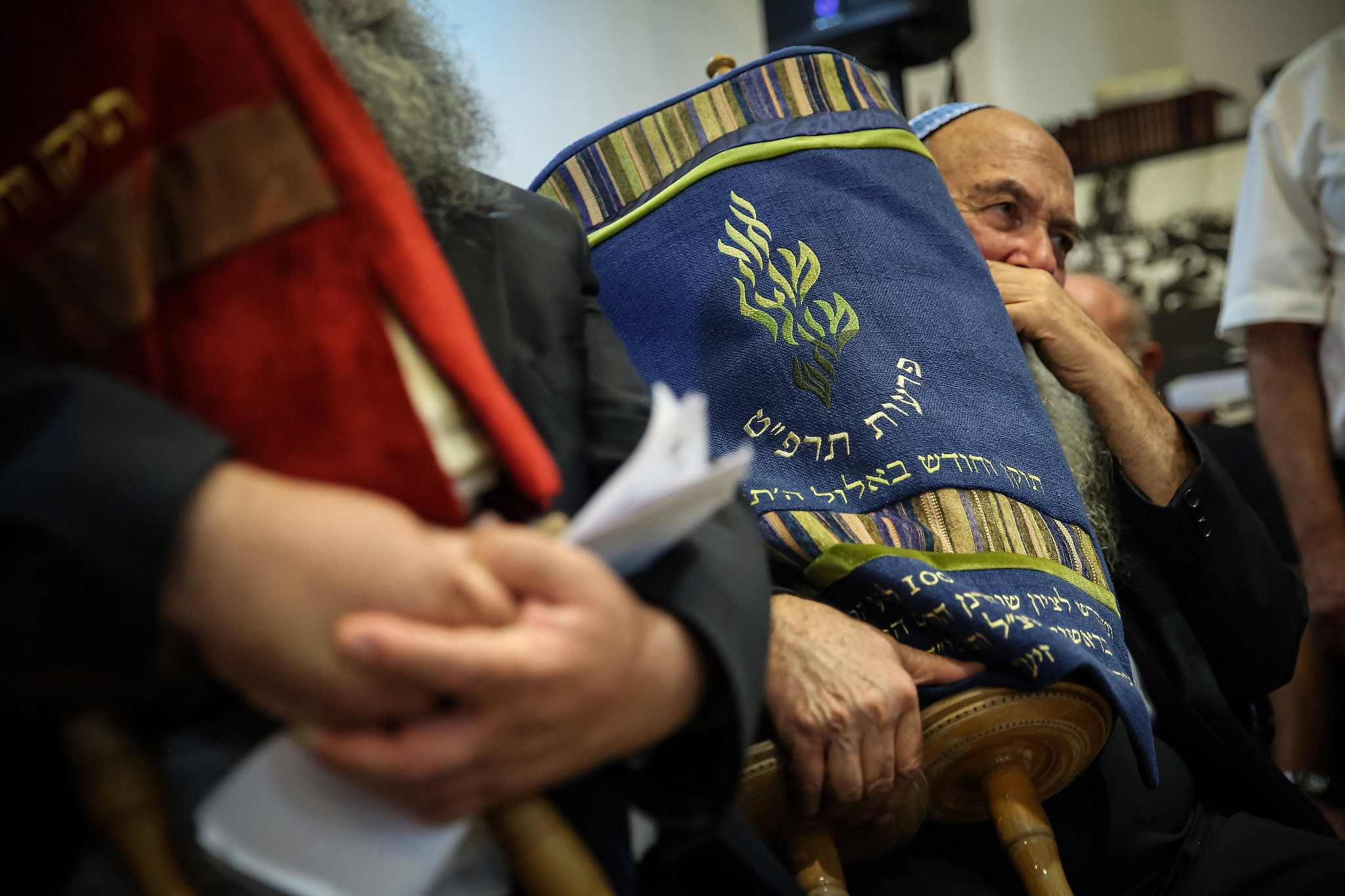 Men hold restored Torah scrolls which were desecrated in the 1929 Western Wall Uprisings (Tarpat), during a ceremony at the Rabbi Kook House, in Jerusalem, August 26, 2014. (Uri Lenz/POOL/Flash90)