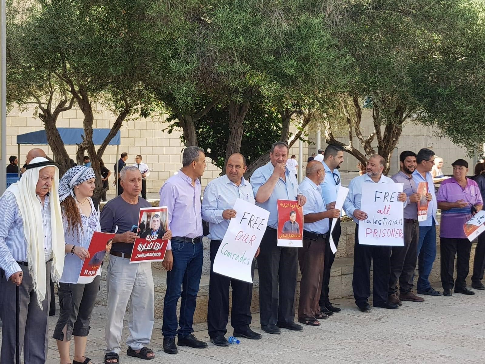 A demonstration against Raja’s detention outside Haifa Magistrate’s Court. United Arab List leader Mansour Abbas, on the right, holds a sign reading: “Free all Palestinian prisoners,” October 2, 2018. (Courtesy of Free Raja Eghbarieh Facebook page)
