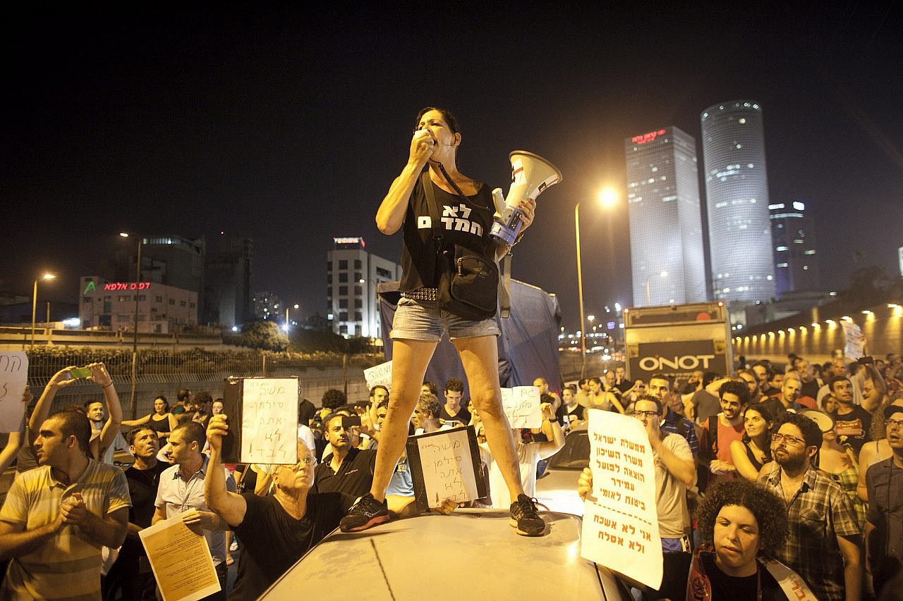 An activist from the Lo Nechmadim/Lo Nechmadot movement leads a crowd of social justice protesters on Tel Aviv's Ayalon Highway, July 15, 2012. (Oren Ziv/Activestills.org)