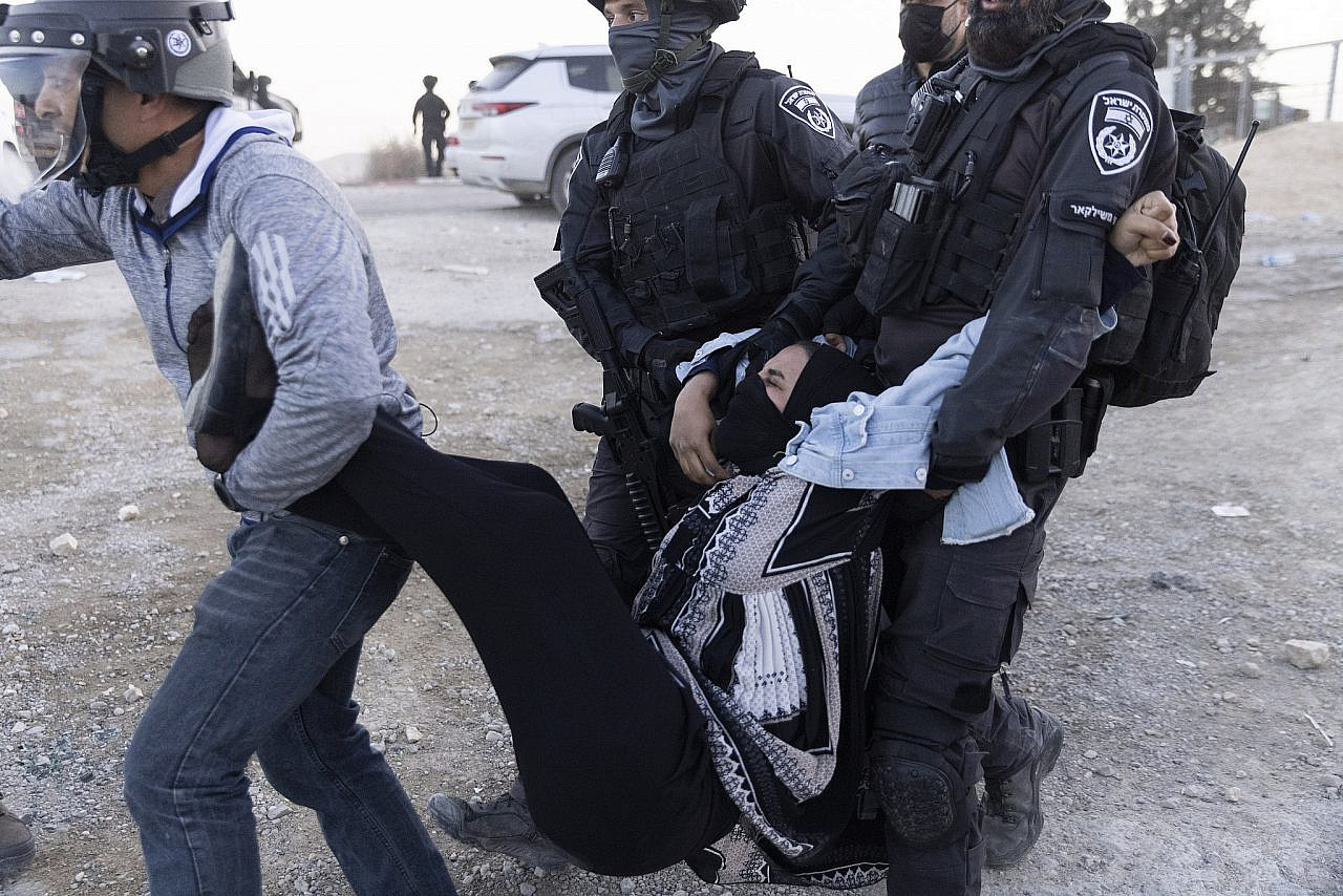 Police arrest a woman during a Bedouin protest against Israel's land expropriation and afforestation, outside Sa'wa al-Atrash, Naqab, January 13, 2022. (Oren Ziv/Activestills.org)