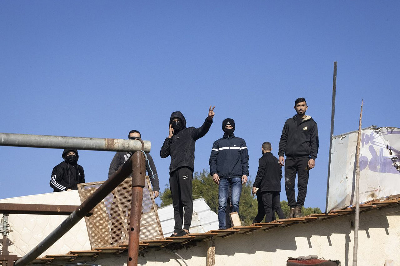 Palestinian youths on the roof of the Salhiyeh family's home, just before the family was due to be forcibly expelled, Sheikh Jarrah, East Jerusalem, January 17, 2022. (Oren Ziv/Activestills.org)