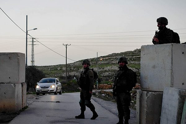 Israeli soldiers operate a checkpoint at the entrance to the Palestinian village of Dir Nizam, occupied West Bank, January 11, 2021. (Rachel Shor)