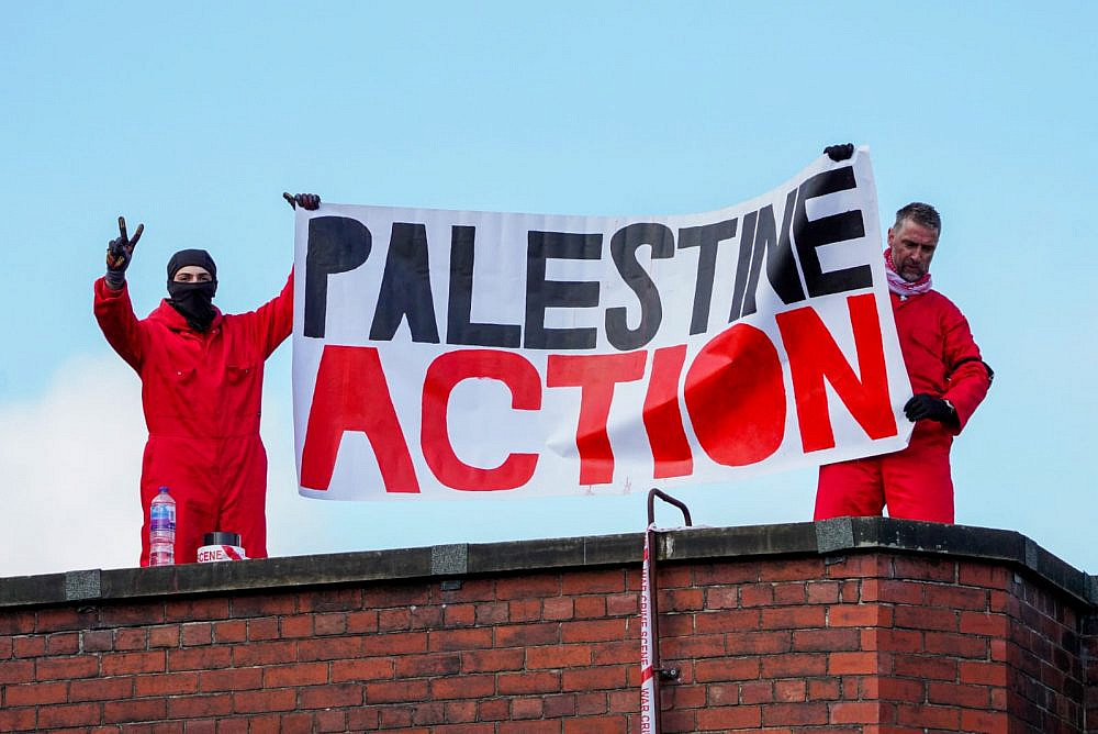 Activists from Palestine Action hold up a banner on top of Elbit Systems factory in Oldham, northern England, August, 2021. (Palestine Action)