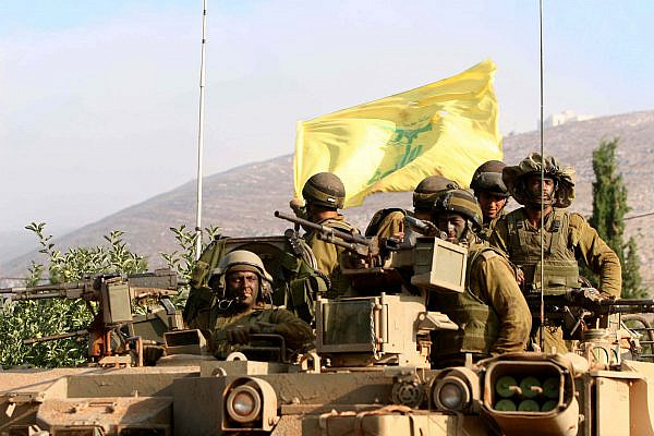 Israeli soldiers wave a tattered Hezbollah flag as they return from fighting around the southern Lebanese village of Marun Al-Ras, July 27, 2006. (Pierre Terdjman/Flash90)