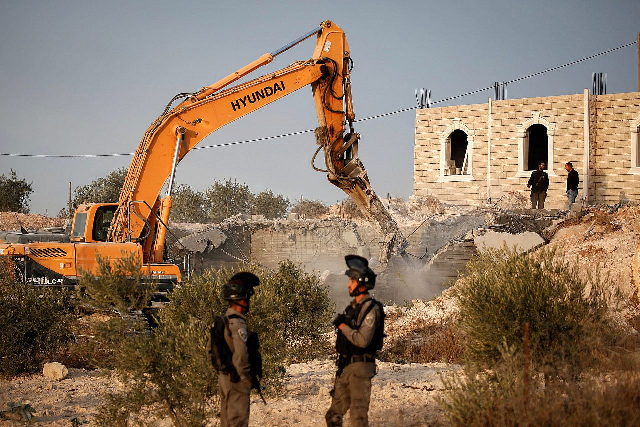 Israeli soldiers and Border Police stand guard while Israeli bulldozers demolish a Palestinian building, in Yatta village south of Hebron in the West Bank, October 17, 2018. (Wisam Hashlamoun/Flash90)