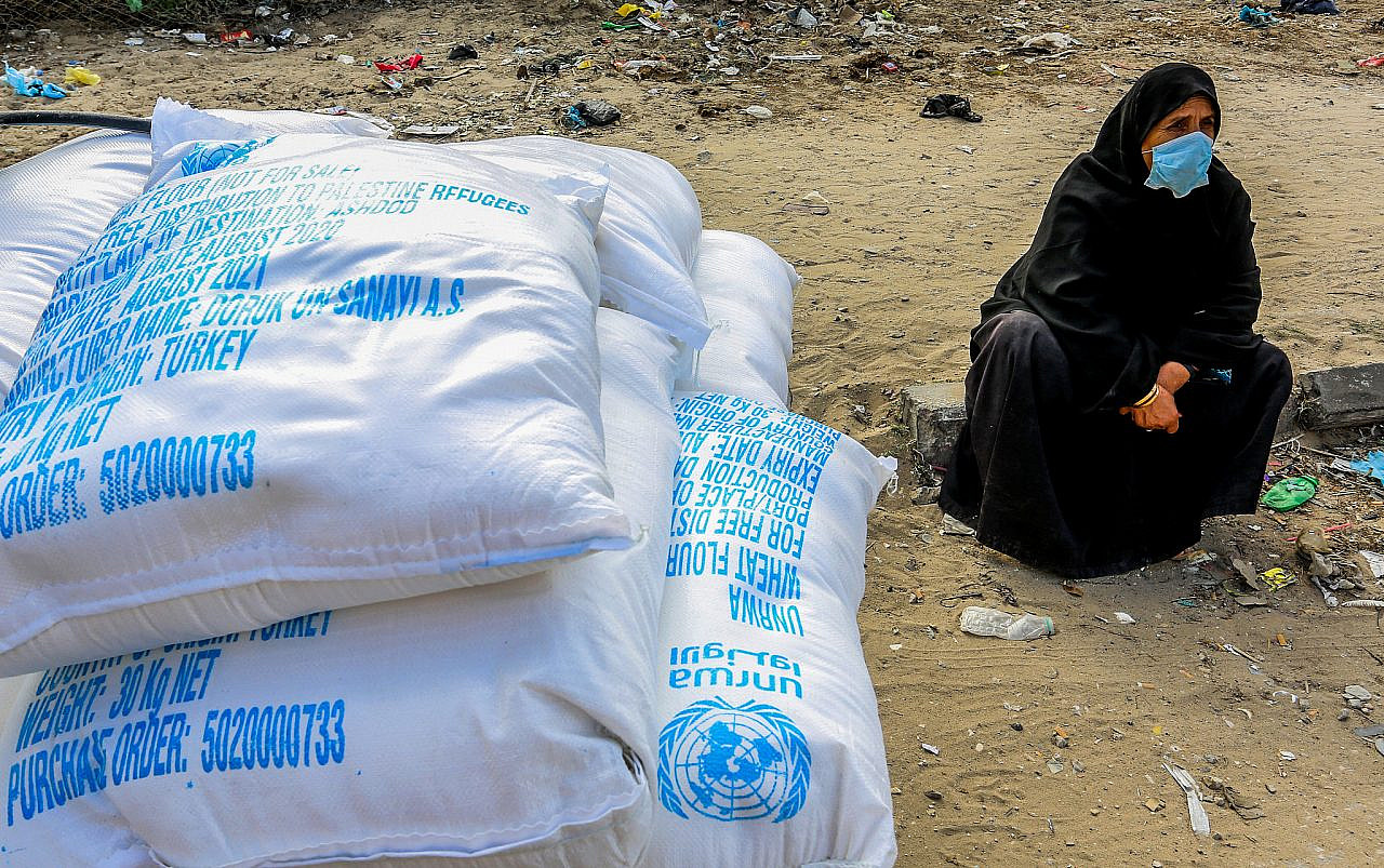 A Palestinian woman receives food aid from a United Nations Relief and Works Agency (UNRWA) distribution center in Khan Yunis, in the southern Gaza Strip, November 26, 2020. (Abed Rahim Khatib/Flash90)
