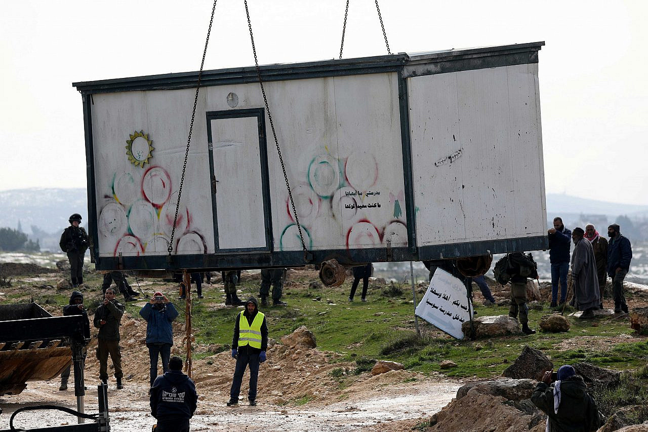 war Israeli forces use a bulldozer to remove a caravan used as a Palestinian school facility in Susia, on the outskirts of Hebron in the occupied West Bank, February 19, 2020. (Wissam Hashlamoun/Flash90)