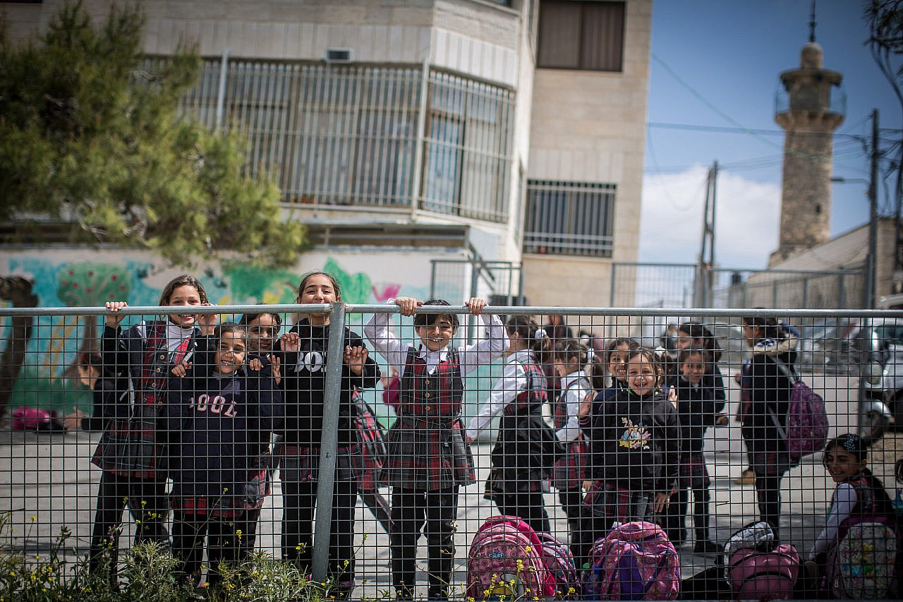 Palestinian children play after school in their playground in the East Jerusalem neighborhood of Shuafat, March 30, 2016. (Hadas Parush/Flash90)