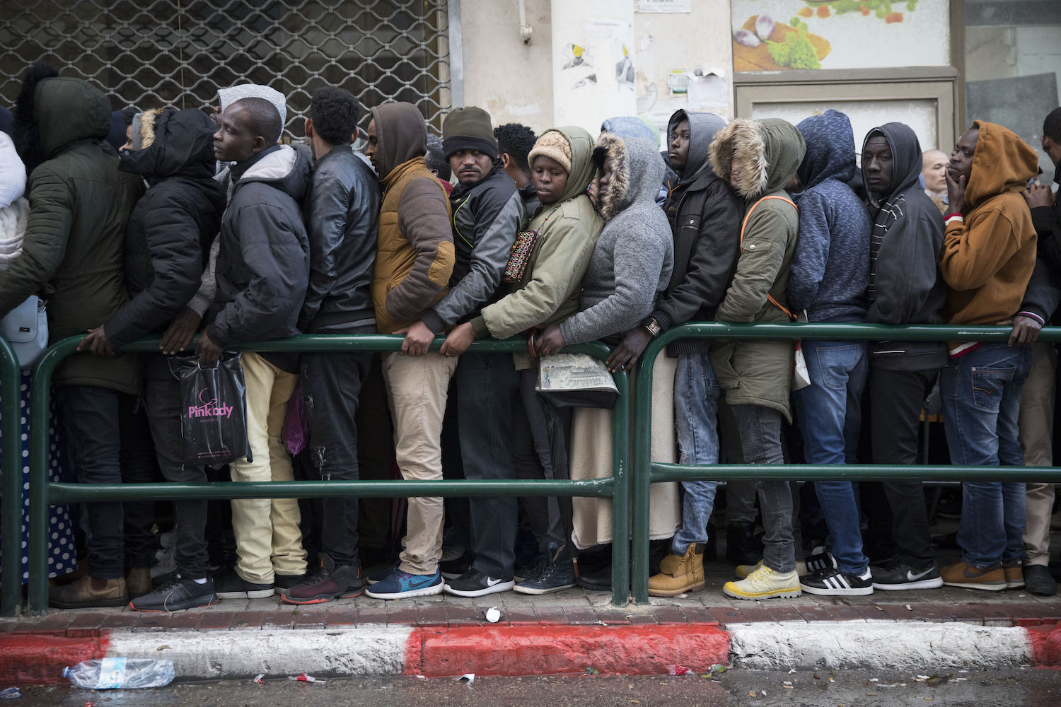 Asylum seekers, mostly from Sudan and Eritrea, wait outside the Interior Ministry in order to submit their asylum requests, south Tel Aviv, January 15, 2018. Many arrive at night, ahead of the opening, and spend hours standing in line in order to get in as soon as possible. (Oren Ziv)