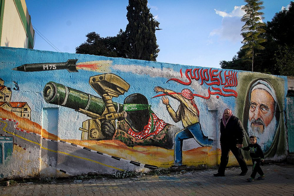 Palestinians walk past a wall painted with a mural during a rally marking the 28th anniversary of Hamas' founding, in Rafah, southern Gaza Strip, December 14, 2015. (Abed Rahim Khatib/Flash90)