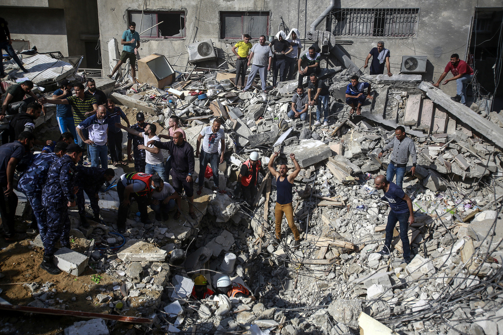 Palestinian rescue workers recover the bodies of victims amid rubble at the site of Israeli air strikes, Gaza City, May 16, 2021. (Atia Mohammed/Flash90)