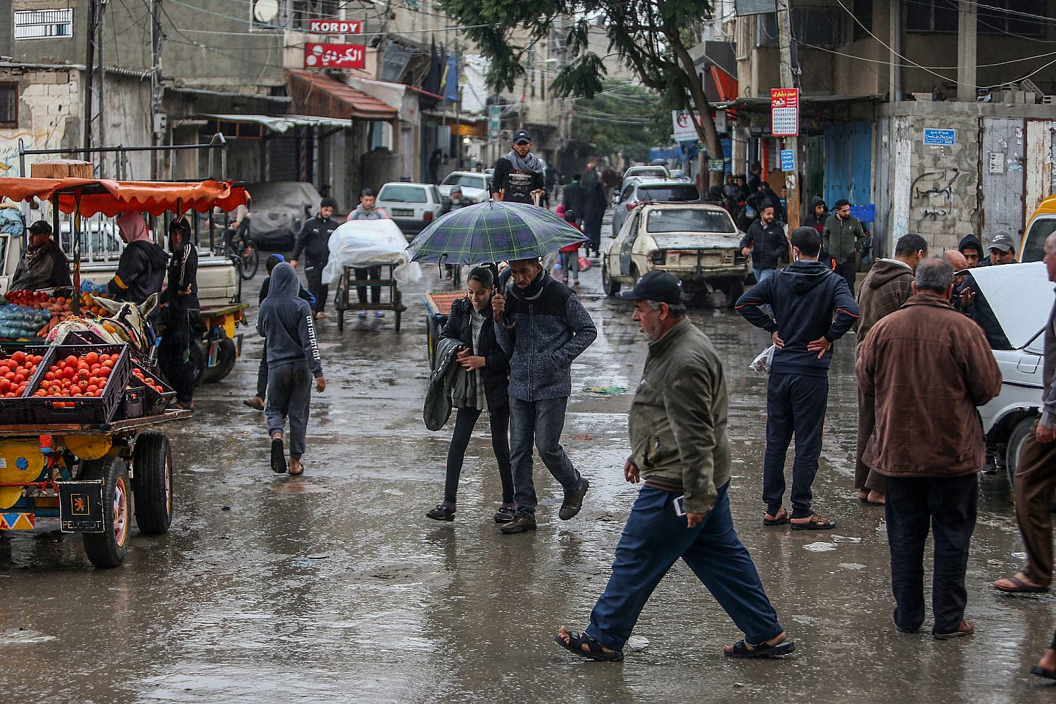 Palestinians during a rainy day on a street in Rafah refugee camp in the southern Gaza Strip, November 19, 2021. (Abed Rahim Khatib/Flash90)