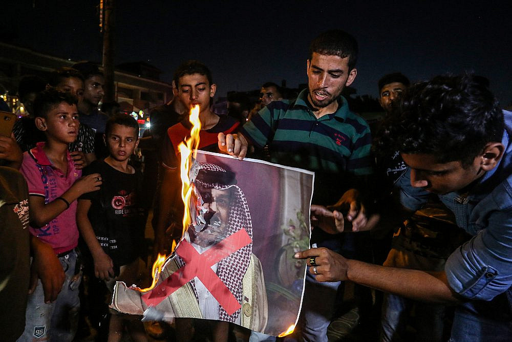 Palestinian protesters burn a photo of Bahrain's ruler Hamad bin Isa Al Khalifa, Rafah, southern Gaza Strip, June 25, 2019. (Abed Rahim Khatib/Flash90)