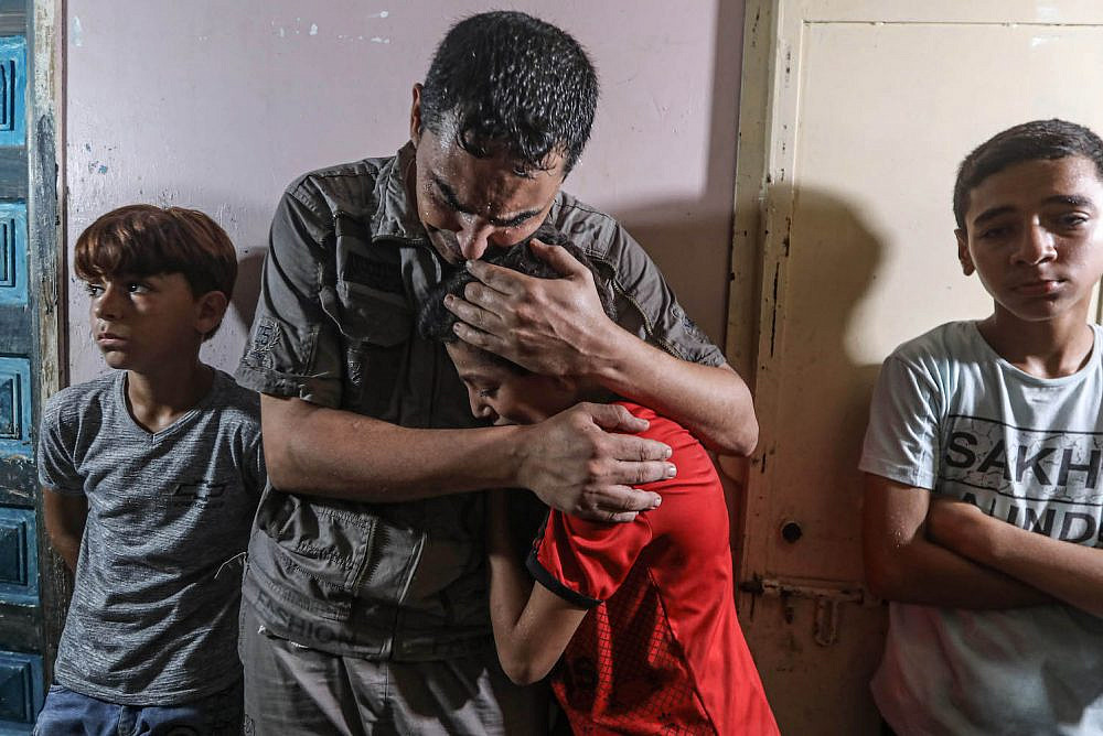 Mourners cry during the funeral of 12-year-old Omar Abu Al-Yenel, who was injured by live fire during confrontations with the Israeli army on the eastern portion of the Israel-Gaza barrier, near Gaza City, August 28, 2021. (Mohammed Zaanoun/Activestills.org)
