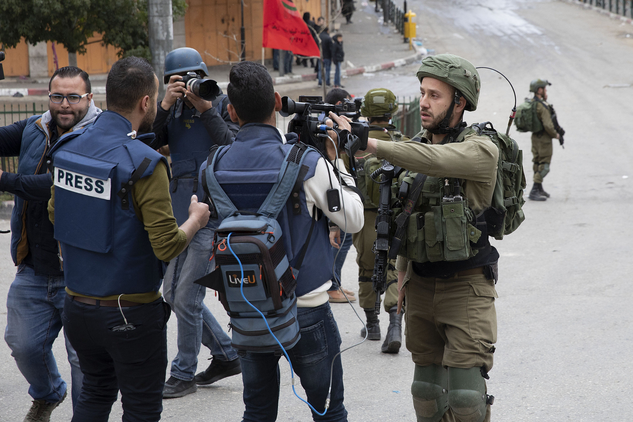 Israeli soldiers confront journalists as Palestinian, Israeli, and international demonstrators march in the West Bank city of Hebron calling to open the Shuhada Street, February 20, 2019. (Oren Ziv/Activestills)