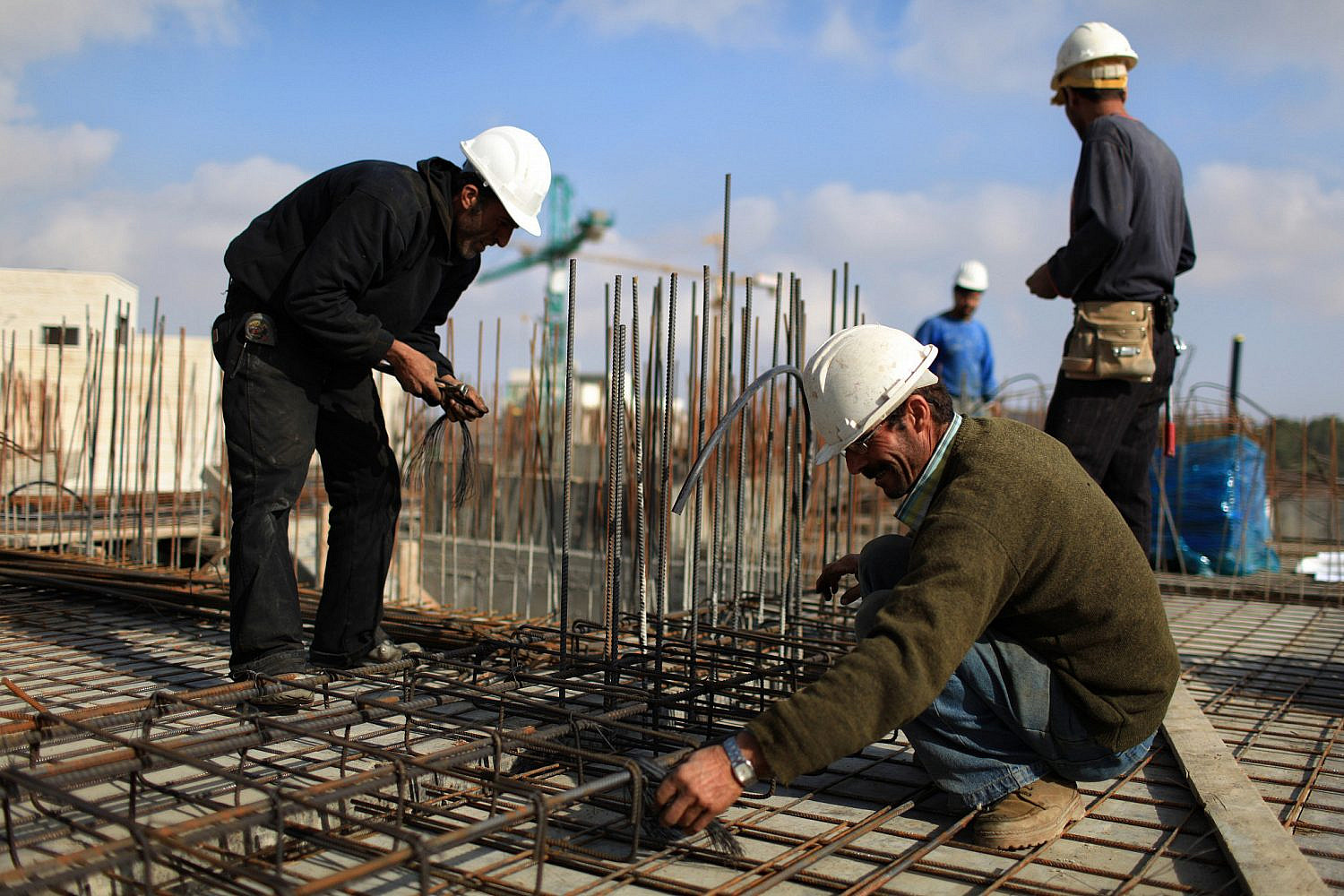Palestinians work at a housing construction site in the Jewish settlement of Har Homa in East Jerusalem, Nov 26, 2009. (Kobi Gideon/Flash90)