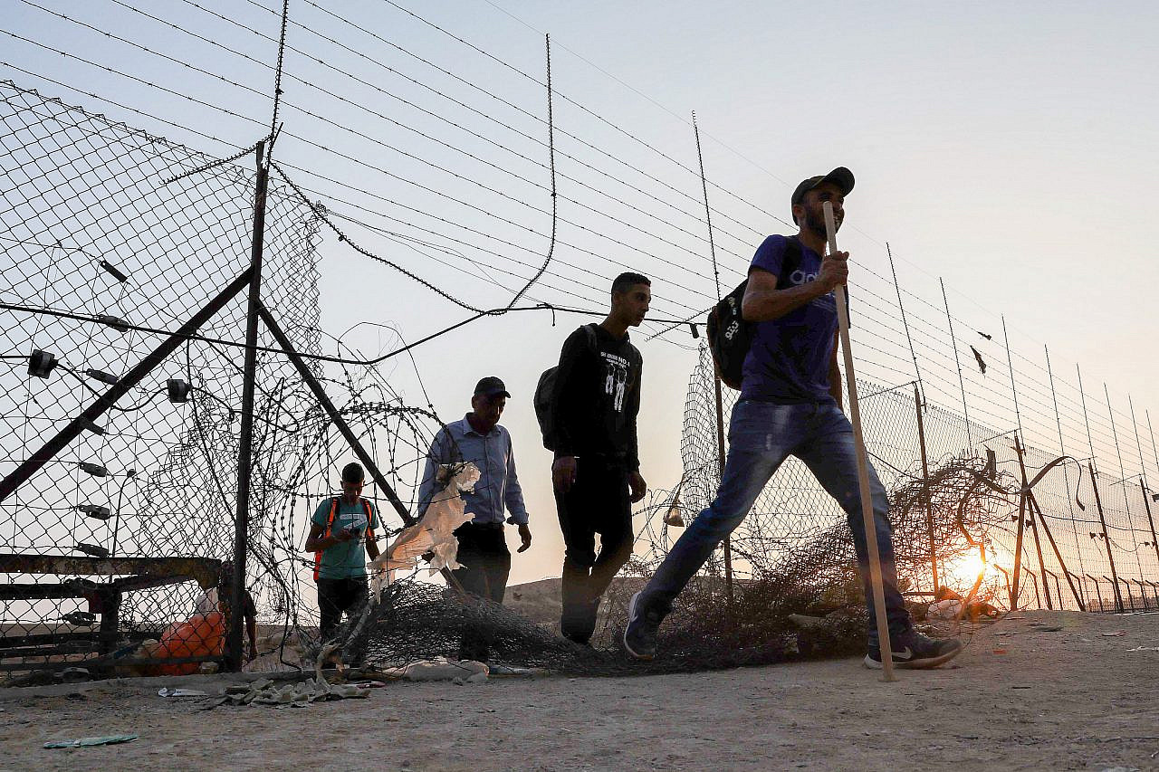 Palestinian workers cross into Israel through a hole in the security barrier near the West Bank city of Hebron, July 25, 2021. (Wisam Hashlamoun/Flash90)