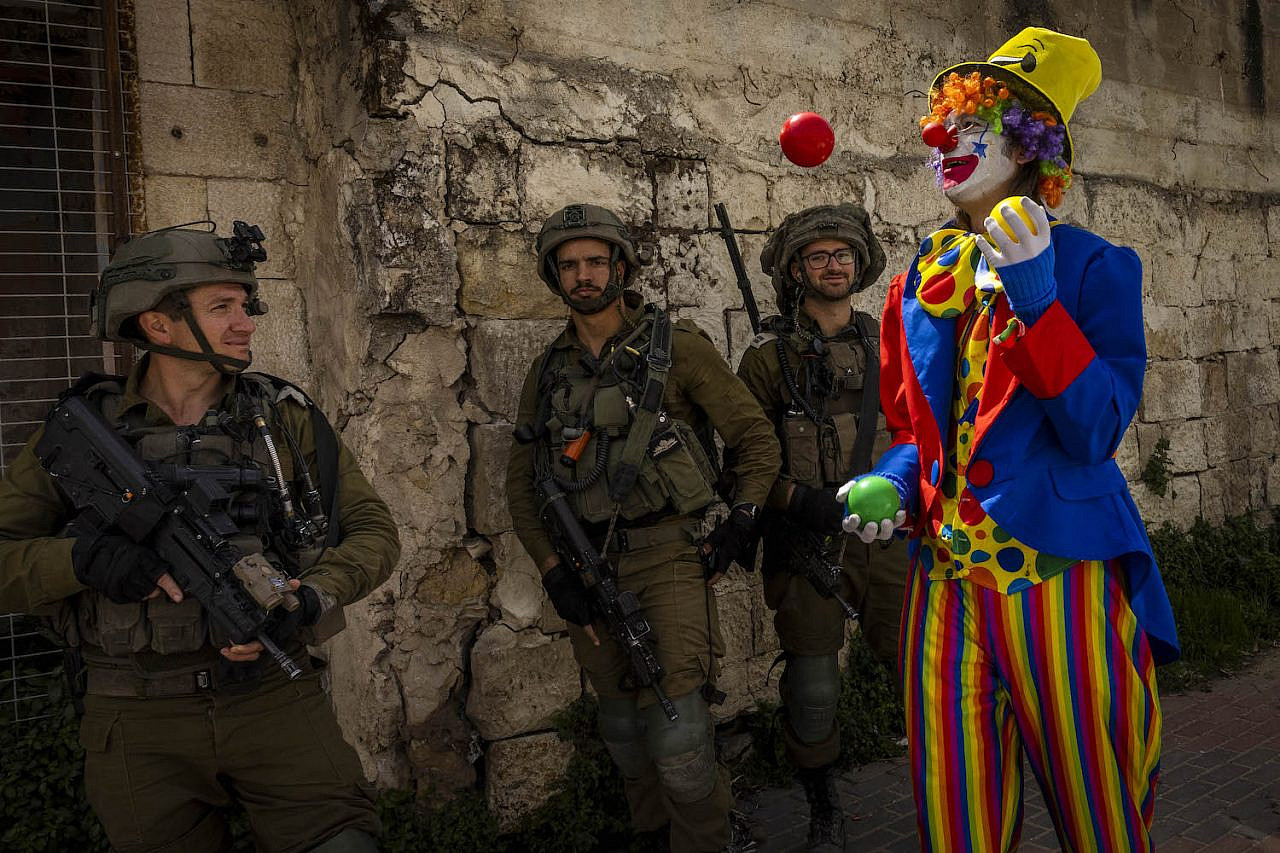 A Jewish settler dressed as a clown takes part in the annual Purim parade in the West Bank city of Hebron, March 17, 2022. (Olivier Fitoussi/Flash90)