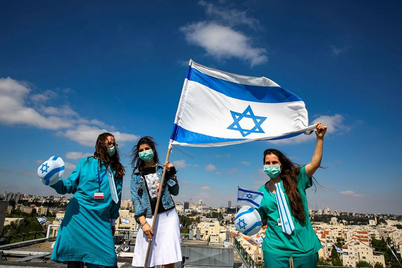Israeli medical staff cheer an Israeli air force acrobatic team as it flies over Shaarei Tsedek hospital in Jerusalem on Israel's 72nd Independence Day. April 29, 2020. (Olivier Fitoussi/Flash90)