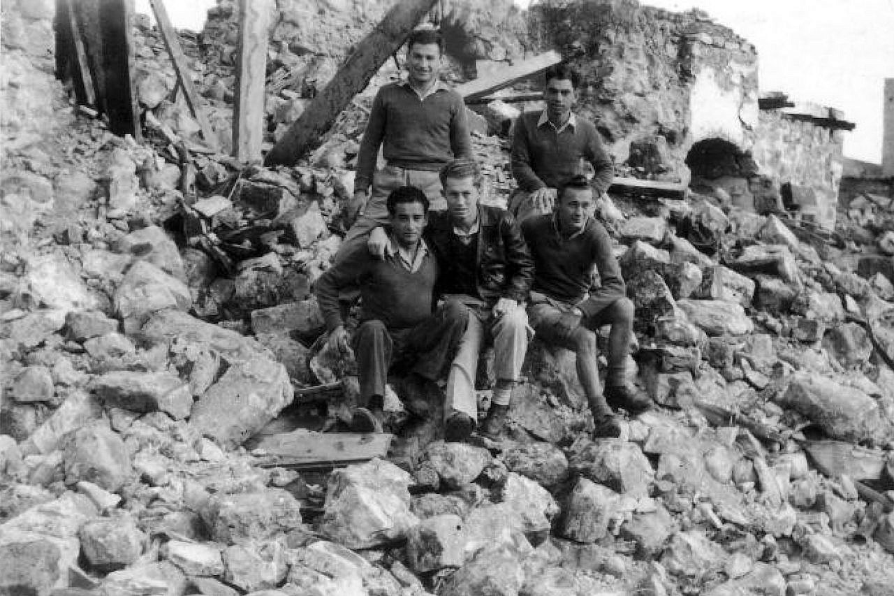 Soldiers from the Palmach brigade sit upon the ruins of a destroyed Palestinian village, 1948. (Palmach Archive)